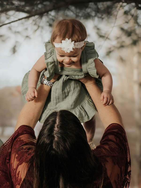 Portrait of mom holding baby in the air