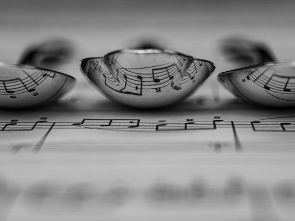 Three spoons on top of music sheet, Black and white photo